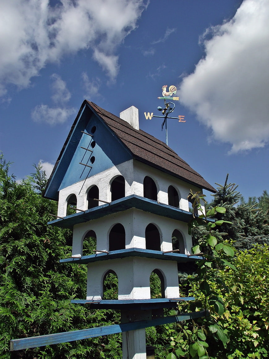 Blue and white multi-level birdhouse with weather vane