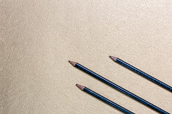 Blue Pencils on Textured Beige Paper Background