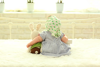 Baby Sitting On White Rug Holding Stuffed Bunny
