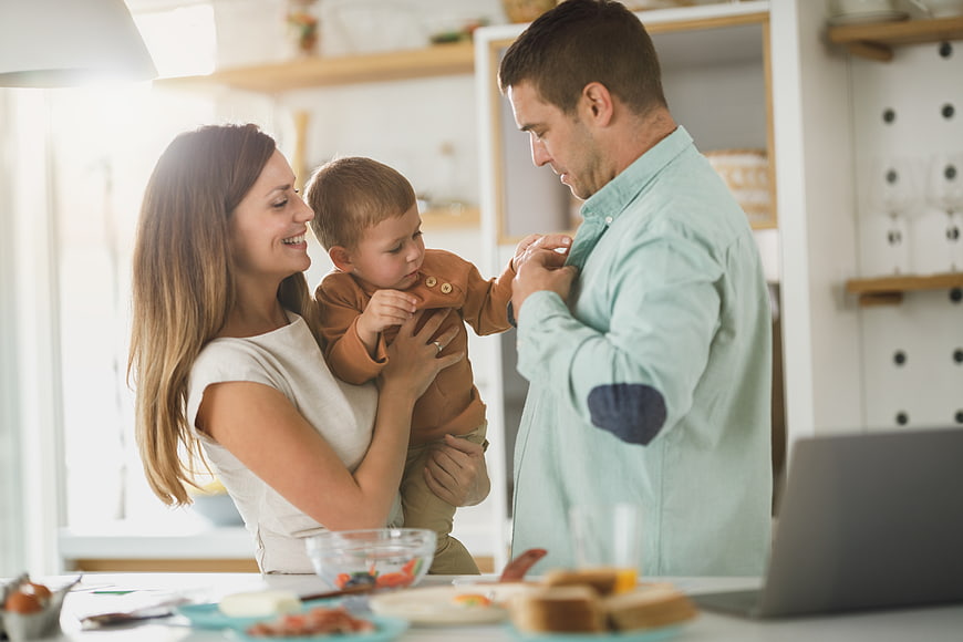 Happy family in kitchen with toddler and breakfast