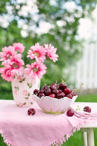 Fresh Cherries and Pink Flowers on Outdoor Table