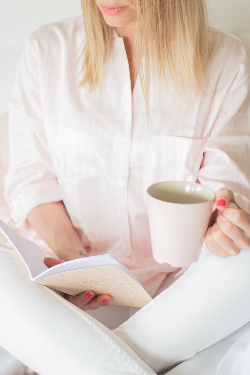 Woman Reading Journal with Coffee in Bed