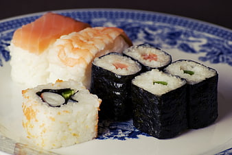 Assorted sushi rolls on a blue and white ceramic plate