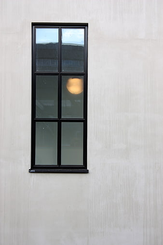 Minimalist black window on textured concrete wall