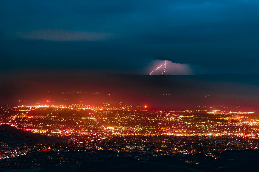 Lightning Strike Over Glowing City at Night