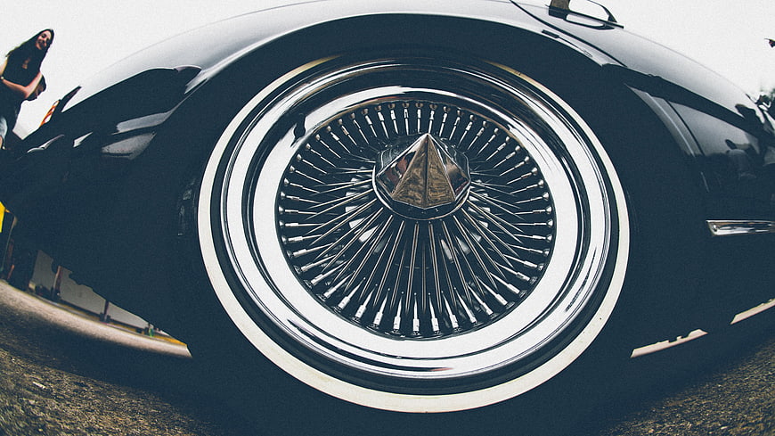 Close-up of vintage car wire wheel with chrome hubcap