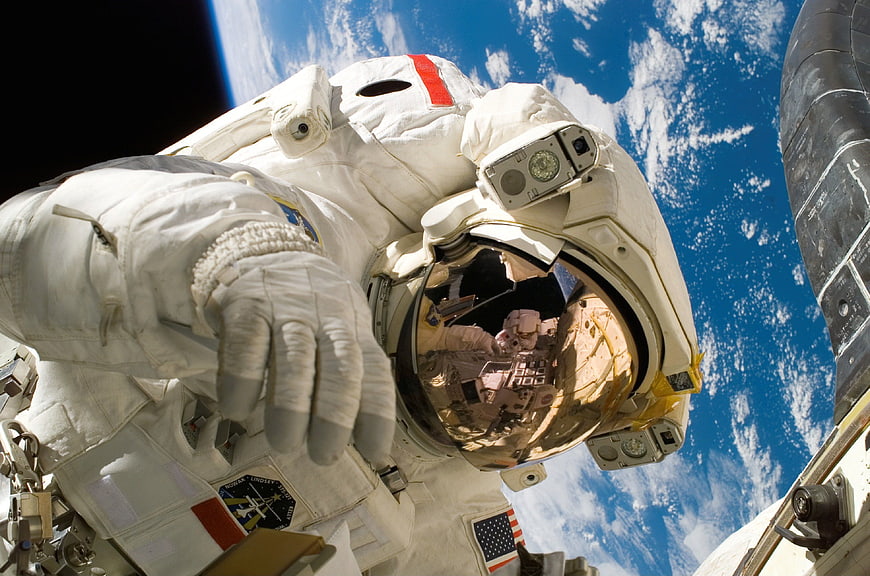 Astronaut in white spacesuit floating in space with Earth background