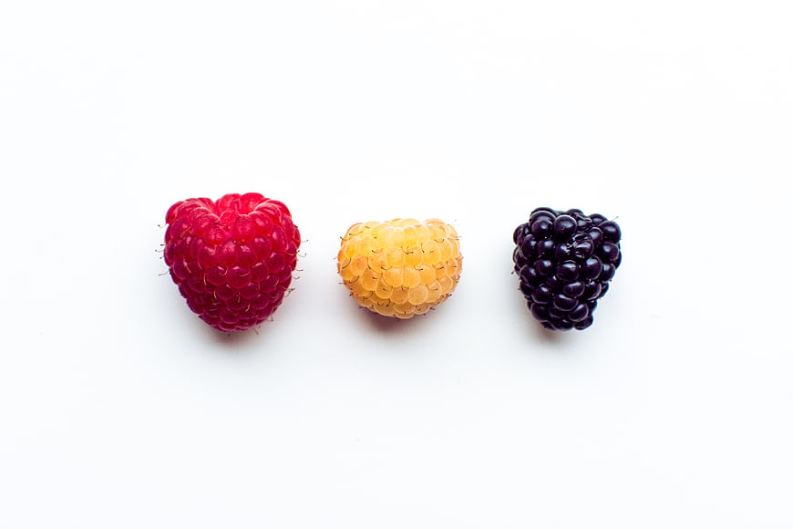Red, Yellow, and Black Raspberries on White Background