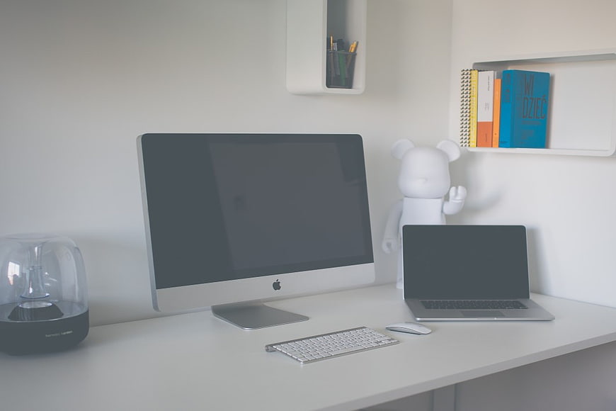 Minimalist white workspace with iMac and laptop