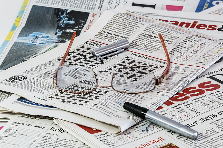 Eyeglasses and pen on newspaper crossword puzzle
