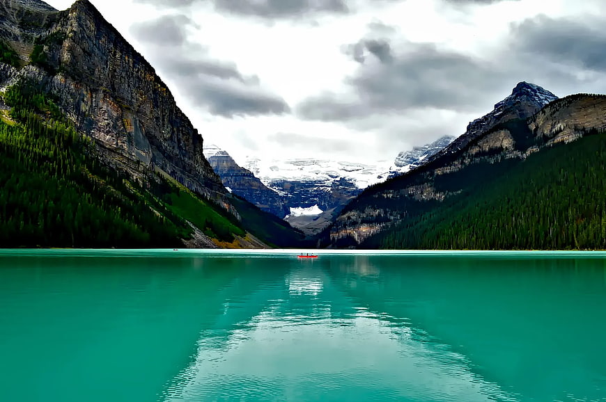 Turquoise Mountain Lake with Red Canoe and Snowy Peaks