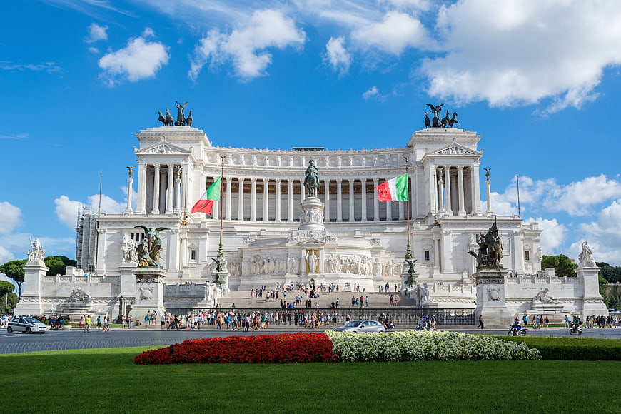 Vittoriano Monument in Rome, Italy with Italian Flags and Blue Sky