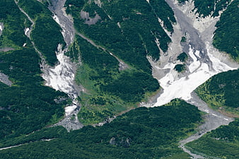 Aerial view of lush green mountains with glacial valleys