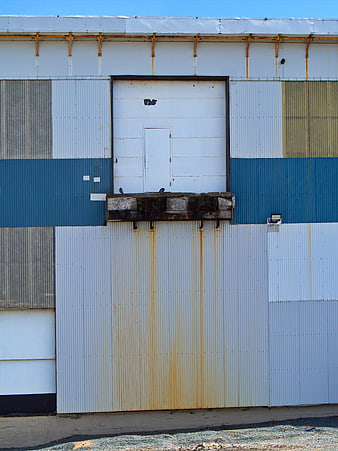 Weathered Industrial Metal Wall with Rust Stains and Blue Stripe