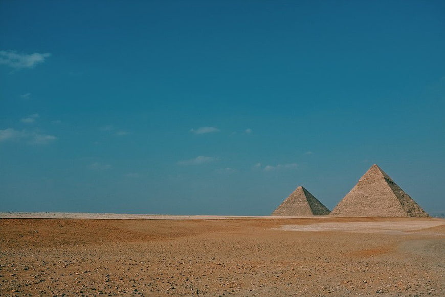 Pyramids of Giza in the desert with blue sky