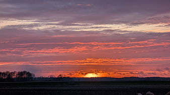 Vibrant Orange Sunset Over Rural Farmland Landscape