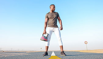 Athletic Man Holding Kettlebell on Desert Road