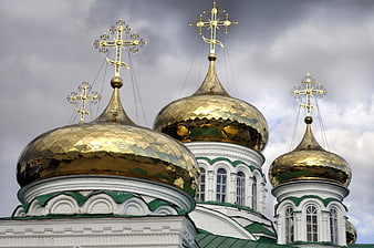 Golden domes of an Orthodox cathedral against cloudy sky
