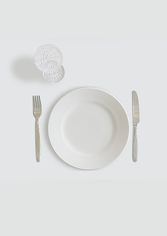 Minimalist White Table Setting with Cutlery and Glass