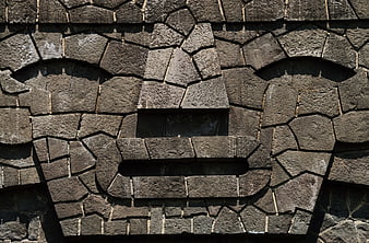 Stone Mosaic Face Sculpture On Textured Wall