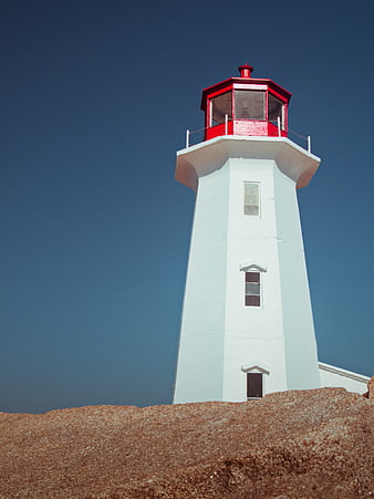 White Lighthouse with Red Roof Against Blue Sky