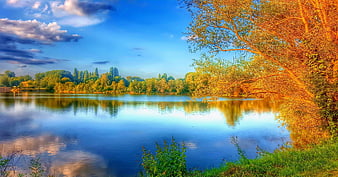 Serene Lake Landscape with Golden Trees and Blue Sky