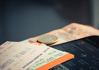 Travel tickets, smartphone, and euro coins on a table