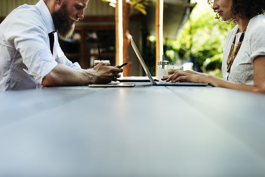 Business Couple Working on Laptop and Smartphone at Cafe