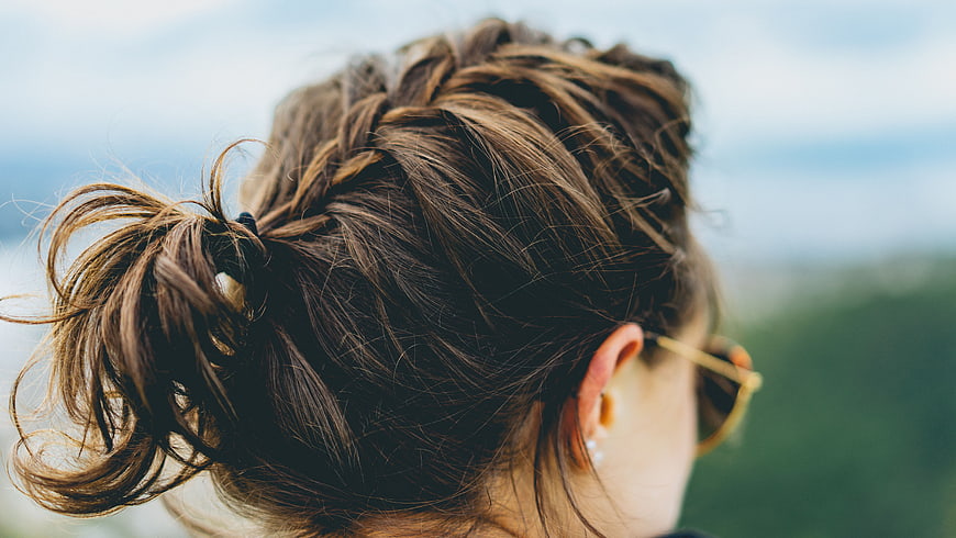 Close-up of woman's braided ponytail hairstyle outdoors