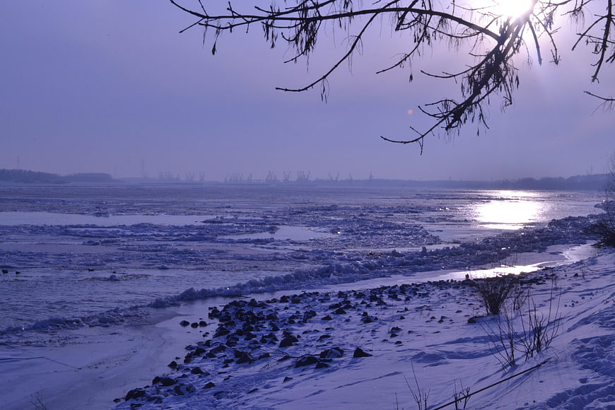 Frozen river landscape with ice floes and winter sunlight