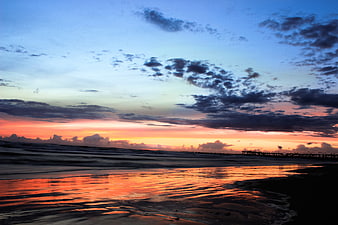 Dramatic Sunset Over Ocean With Silhouetted Pier