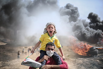 Man Carrying Shouting Boy Amidst Burning Tires and Smoke