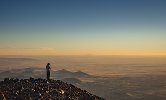 Lone Hiker on Rocky Mountain Summit at Golden Hour