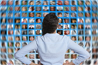 Woman facing digital network of blurred faces on blue background