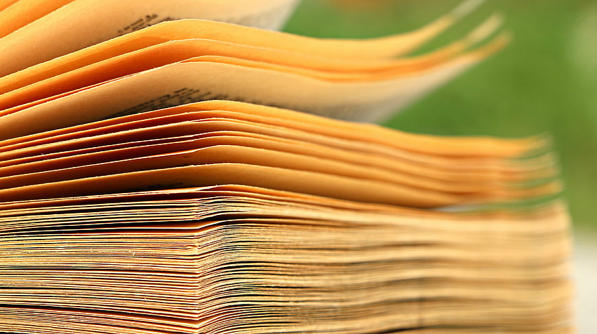 Close-up of yellowed book pages fanning out in the wind