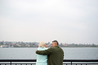 Senior couple embracing by waterfront railing