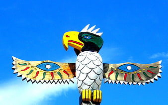 Colorful Painted Wooden Eagle Sculpture Against Blue Sky