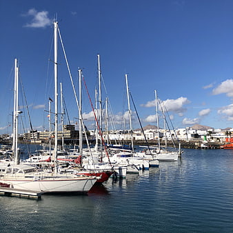 Sailboats docked in a sunny Mediterranean marina