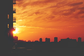 Silhouette of City Skyline Against Vibrant Orange Sunset Sky