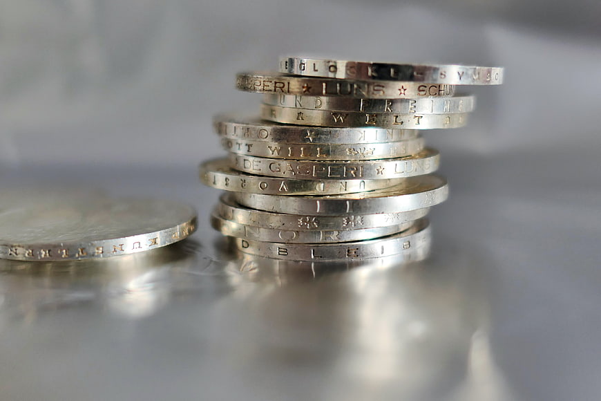 Stack of German Mark Coins on Reflective Surface