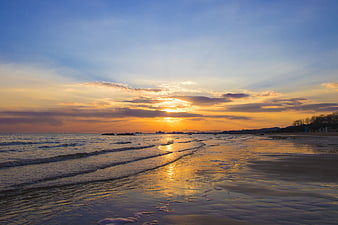 Golden Sunset Over Ocean Waves and Sandy Beach