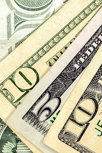 Close-up of overlapping US ten dollar bills showing currency texture