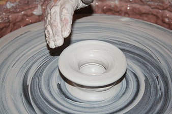 Potter's Hands Shaping Wet Clay on a Spinning Wheel