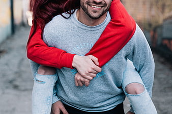 Happy couple piggyback ride in urban alley