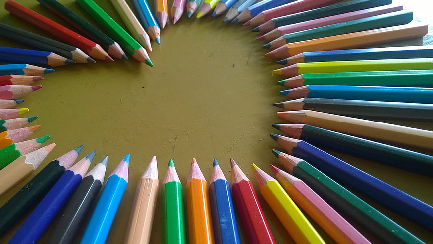 Colorful Pencils Arranged in a Circle on Green Background