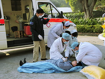 Medical team performing emergency first aid near ambulance