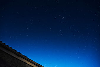 Starry Night Sky Above a Dark Roof Silhouette