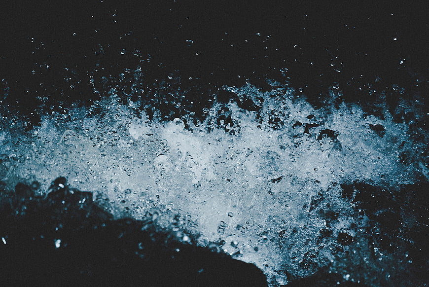 Dynamic blue water splash against dark background