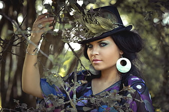 Woman in floral hat posing in forest