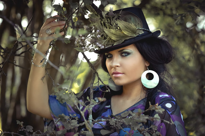 Woman in floral hat posing in forest